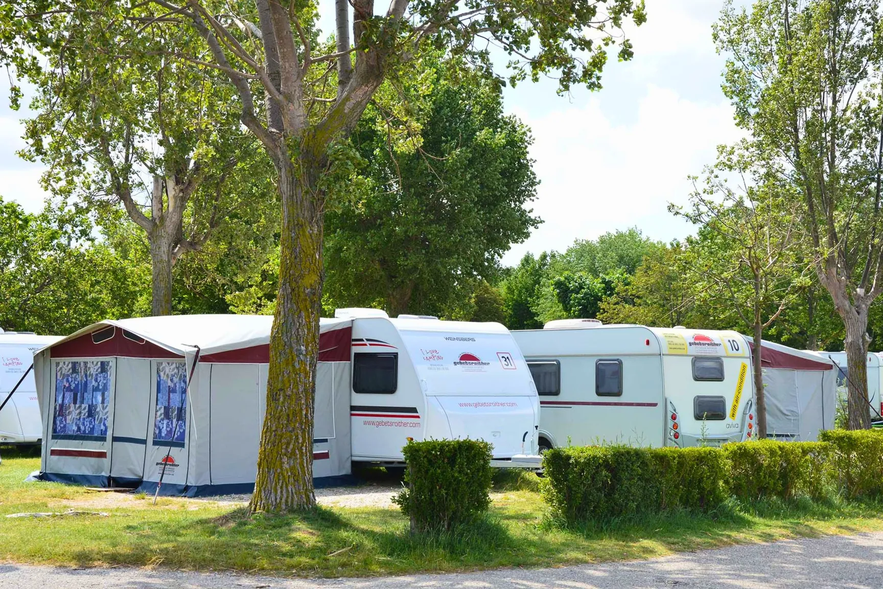 Wohnwägen unter im Schatten unter Bäumen am Camping Resort Riegersburg